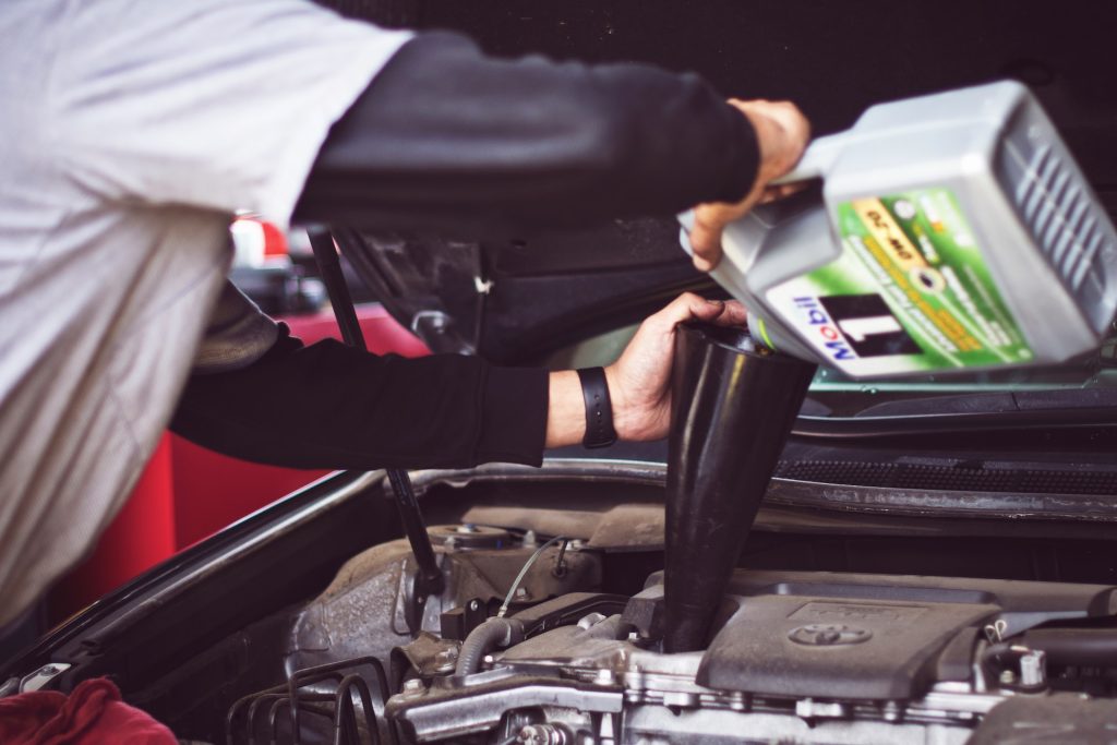 putting oil in car